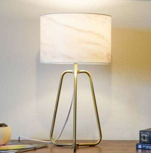 Small modern stylish desk lamp with marble shade and bronze base on table