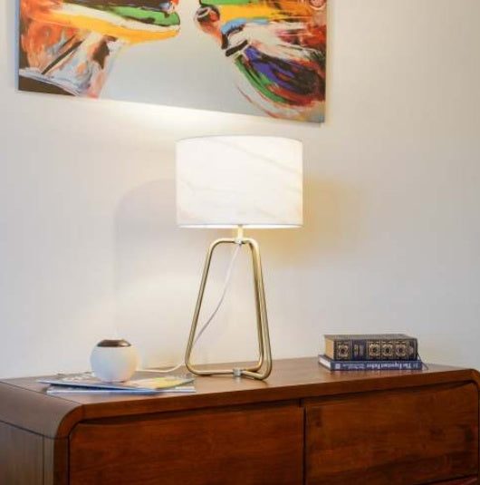 Small modern stylish desk lamp with marble-patterned shade and bronze metal base on table