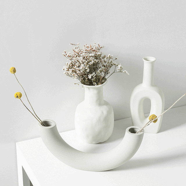 Minimalist Nordic decoration ceramic vase with matte glaze on wooden table in modern interior