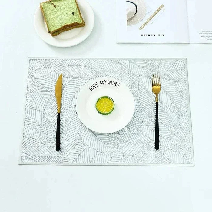 Golden rectangle table mat with hollow leaf design on dining table