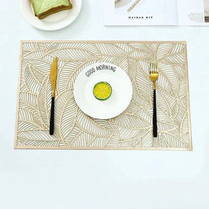 Golden rectangle table mat with hollow leaf design made of PVC and vinyl on a dining table