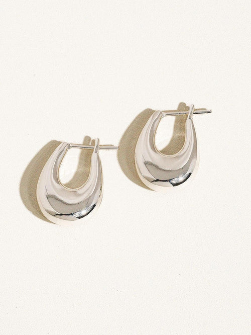 “Silver Droplet Hoop Earrings” – Elegant earrings on soft grey velvet with natural light

“18K Silver Hoops Minimal Style” – Close-up of earring worn with a neutral outfit