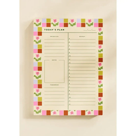 “Floral Checkered Planner Pad” – Close-up of floral-bordered daily planner with pen and coffee mug

“Pretty & Productive Desk Setup” – Notepad styled on a workspace with colorful stationery
