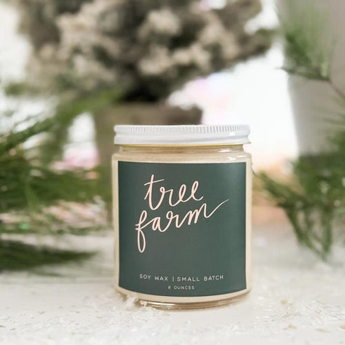 “Amber glass candle labeled TREE FARM surrounded by pine needles and ornaments.”

“Hand-poured soy candle burning beside evergreen branches and twinkle lights.”

“Tree Farm candle styled on a wooden tray with pinecones and a cozy blanket.”